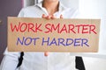 Business woman holding a banner with Ã¢â¬ÅWork smarter not harderÃ¢â¬Â